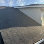 New dark architectural shingles installed on the upper roof plane during reroofing, Bend, Oregon