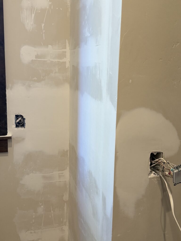 Sanded and feathered drywall patch near an electrical outlet, prepped for paint, Sunriver, Oregon