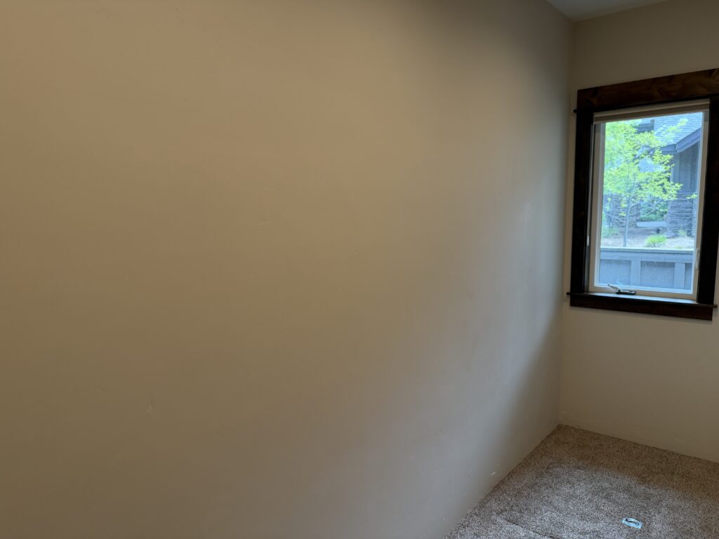 Completed bedroom wall near window after drywall repair and paint, Sunriver, Oregon
