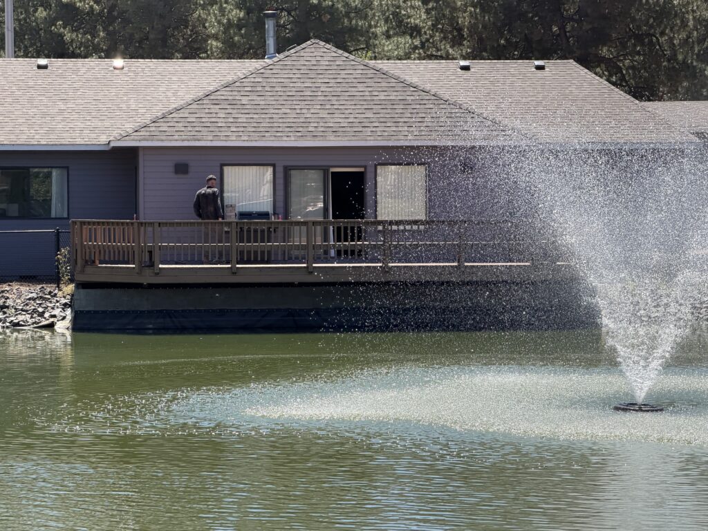 Completed pondside deck with the community fountain visible in the pond