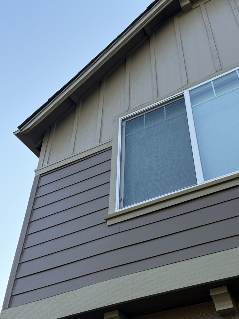 Close-up of freshly painted siding and gable trim after exterior repaint