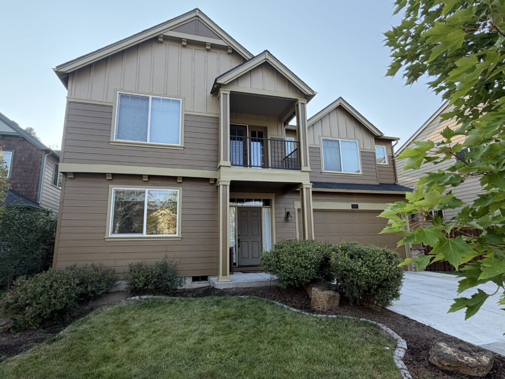 Angled view of completed exterior house painting with finished landscaping and entry